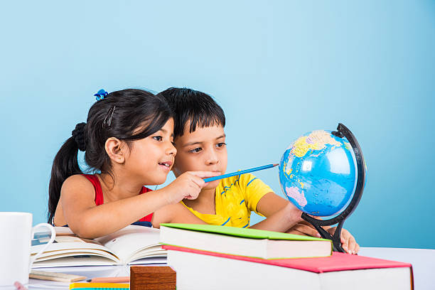 Wel Come indian boy and girl studying with globe on study table, asian kids studying, indian kids studying geography, kids doing homework or home work, two kids studying on table